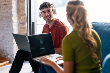 Shot of business people working with laptop while sitting on a couch in a coworking place
