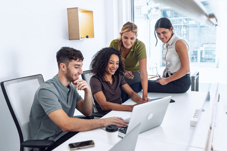 Shot of business people working with laptop and talking about their new project together in a coworking placeの写真素材
