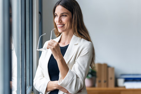 Shot of beautiful businesswoman taking a break while looking forwards to the window at the office.の写真素材