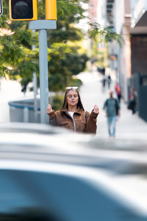 Shot of cheerful woman relaxing while waiting to cross the road in the city