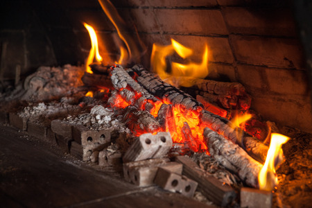 Wooden log burning in the fireplace of a pizzeria Wood Oven