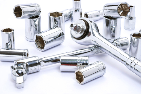 Close up Ratchet and a set of interchangeable heads for chrome socket wrench. Isolated on white background.の写真素材