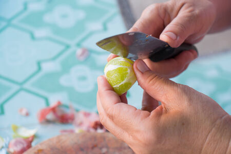 Human hands cut lemon peels with a knife の写真素材
