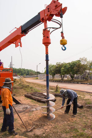 The man work with drill machine digging a hole for a pole の写真素材