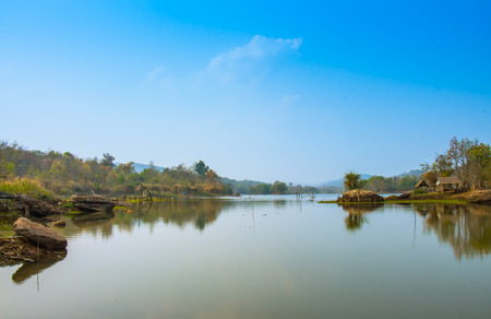 Green lake with a stone and a hutの写真素材