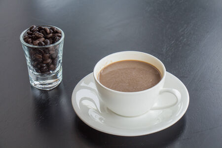 Coffee cup and beans in glassの写真素材