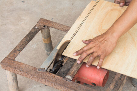 Carpenter using electrical saw for cutting woodの写真素材