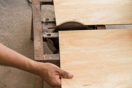 Carpenter using electrical saw for cutting woodの写真素材