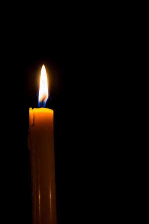 Yellow candle on the dark background and bokehの写真素材