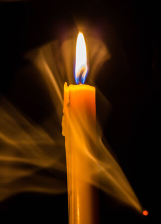 Yellow candle on the background and smokeの写真素材