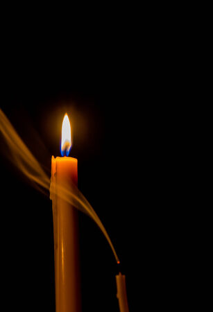 Yellow candle on the background and smokeの写真素材