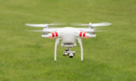 Flying helicopter with camera over grassの写真素材