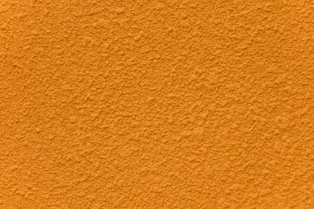 Orange cement wall painted with a rough surface の写真素材