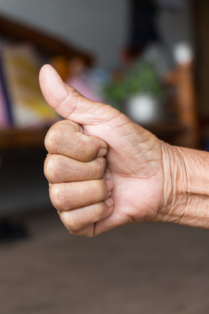 Hand with thumb up .Like sign by old womanの写真素材