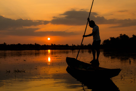 fishermen on a boat at sunriseの写真素材