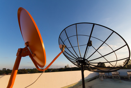 Difference size satellite dish for difference Usability : The black satellite dish is c band for free tv.The Orange satellite dish is ku band watch tv with costs.の写真素材