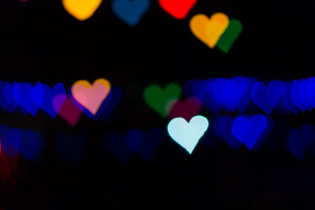 Color Bokeh on a dark background with hearts use for graphic designの写真素材