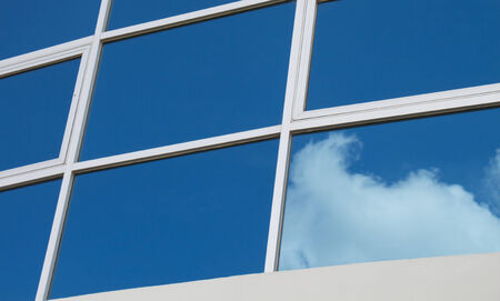 Clouds reflected in windows of modern office building