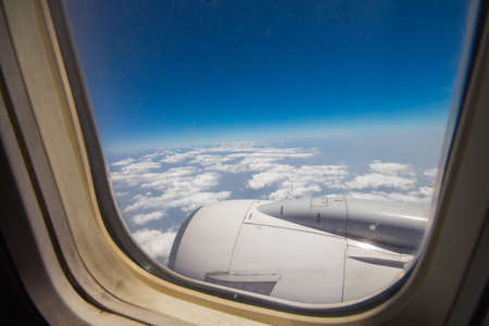 Clouds and sky as seen through window of an aircraftの写真素材