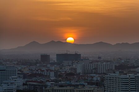 sunrise and the city was filled with buildings and construction. The background is 
mountainの写真素材