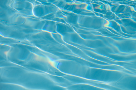 Surface of water on the swimming pool reflecting the sunの写真素材