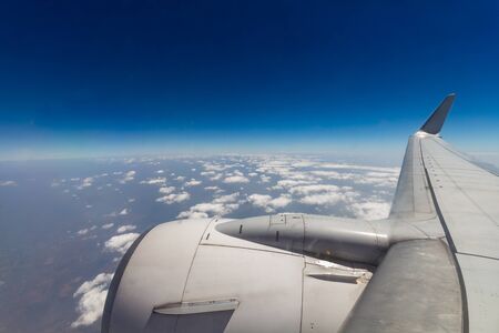 Clouds and sky as seen through window of an aircraftの写真素材