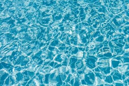 Surface of water on the swimming pool reflecting the sunの写真素材