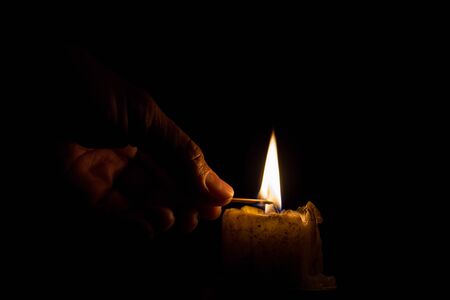 Men are using the match to light the candleの写真素材