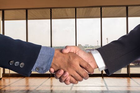 Business men shaking hands in airport.の写真素材