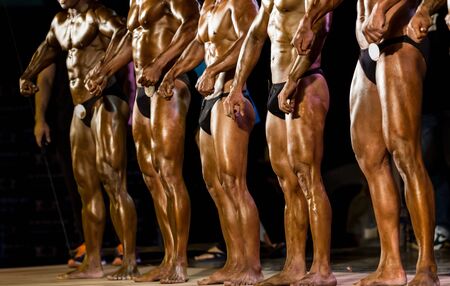 Bodybuilder posing in studio on stageの写真素材