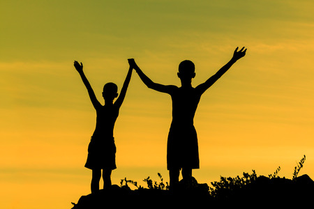 Silhouette success boy on the mountainの写真素材