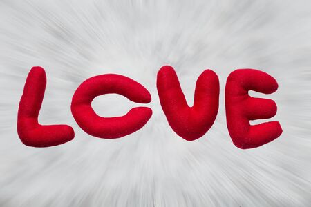 Red letters letters made of cloth written word love. On blur zoom background.の写真素材