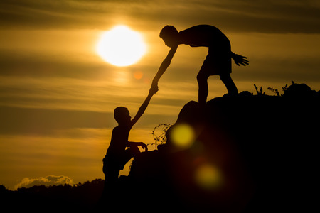 Silhouette of  helping hand of a friend.の写真素材