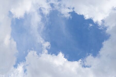 Cloudy on blue sky with a frame shaped like a fish.の写真素材