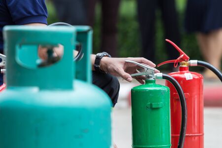 Instructor showing how to use a fire extinguisher on a training fireの写真素材