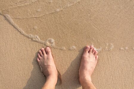 Bare foot on the beach.