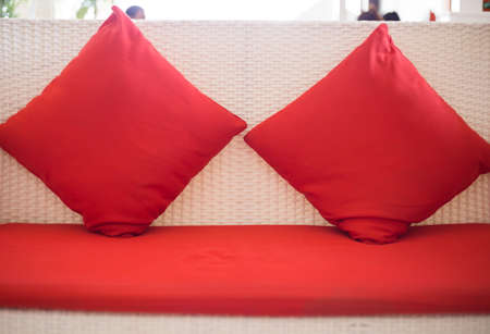Red backrest pillow on the white sofa bed.の写真素材