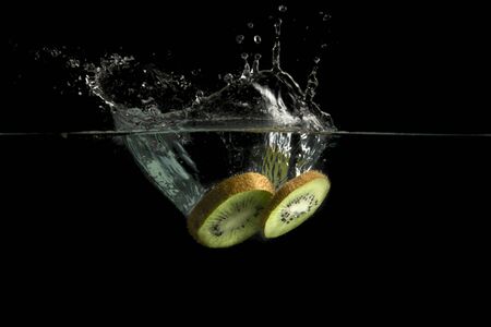 Kiwi fruit splashes in waterの写真素材