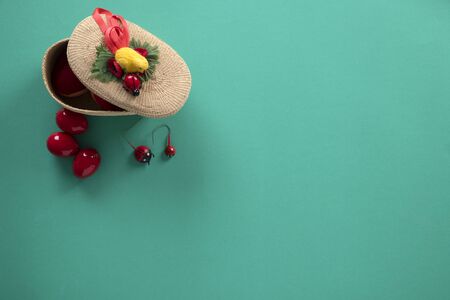 Easter wicker basket full of decorative red eggs on a turquoise surface