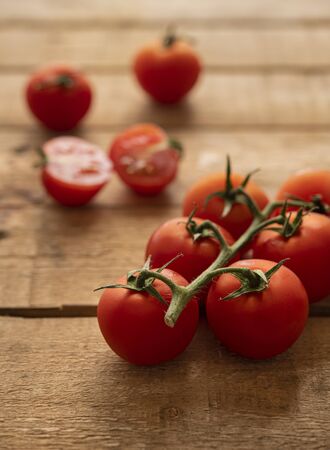 Small tomatoes on a wooden table with day lightの写真素材