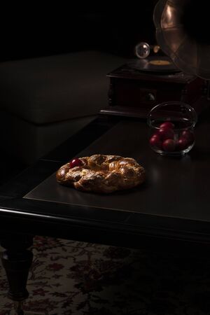 Sweet easter bread with red eggs and a gramophone on a wooden table in the living roomの写真素材