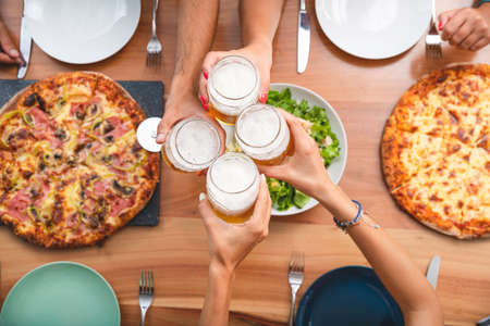 Top View from Young Friends Toasting Beer and Having Pizza on the Balcony. Summer Concept with Buddies Drinking and Eatingの写真素材
