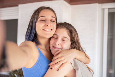 Two Sisters Hugging Each Other with Loveの写真素材