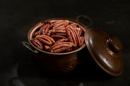 Fresh Pecan in a Metal Bronze Bowl on a Dark Background With the Top of the Bowl Wide Open
