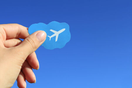 Airplane picture in the hand with blue sky backgroundの写真素材