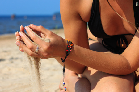 Closeup of woman hands pouring sand