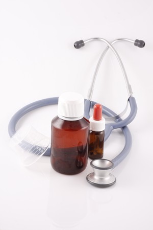 Stethoscope and bottles on white backgroundの写真素材