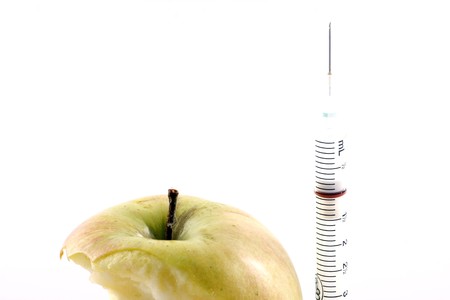 Apple with syringe on white backgroundの写真素材