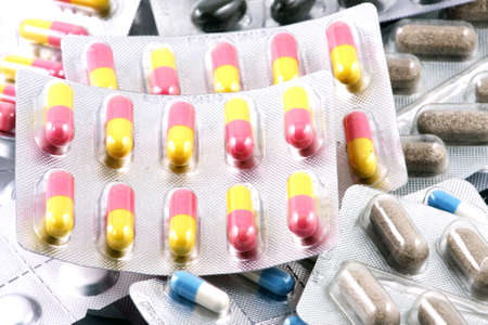 Pills of many shapes and colors grouped together