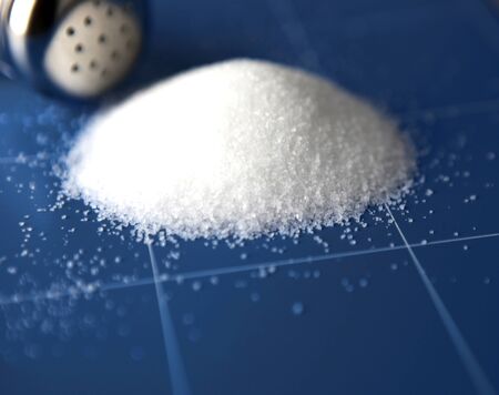 Glass saltcellar with salt on blue backgroundの写真素材